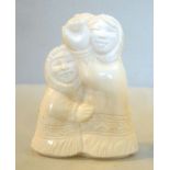 An Inuit carved marine ivory group, two embracing figures, one holding a small,