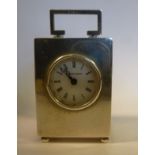 A silver rectangular box cased miniature timepiece with a folding top handle and a circular window,