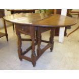 A late 18thC/early 19thC beech and elm gateleg table, the planked top with round corners,