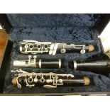 A B & M four section stainless steel and black plastic clarinet, in a fabric lined,