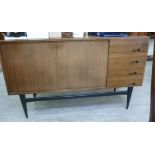 A 1970s Jonelle teak finished sideboard with a pair of cupboard doors and four drawers,