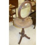 An Edwardian mahogany shaving stand, the rotating circular mirror on a ring turned,