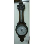 A late Victorian oak framed aneroid barometer with a thermometer and a silvered dial 36''h