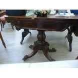 A mid Victorian mahogany tea table with a rotating foldover top and a carved frieze,