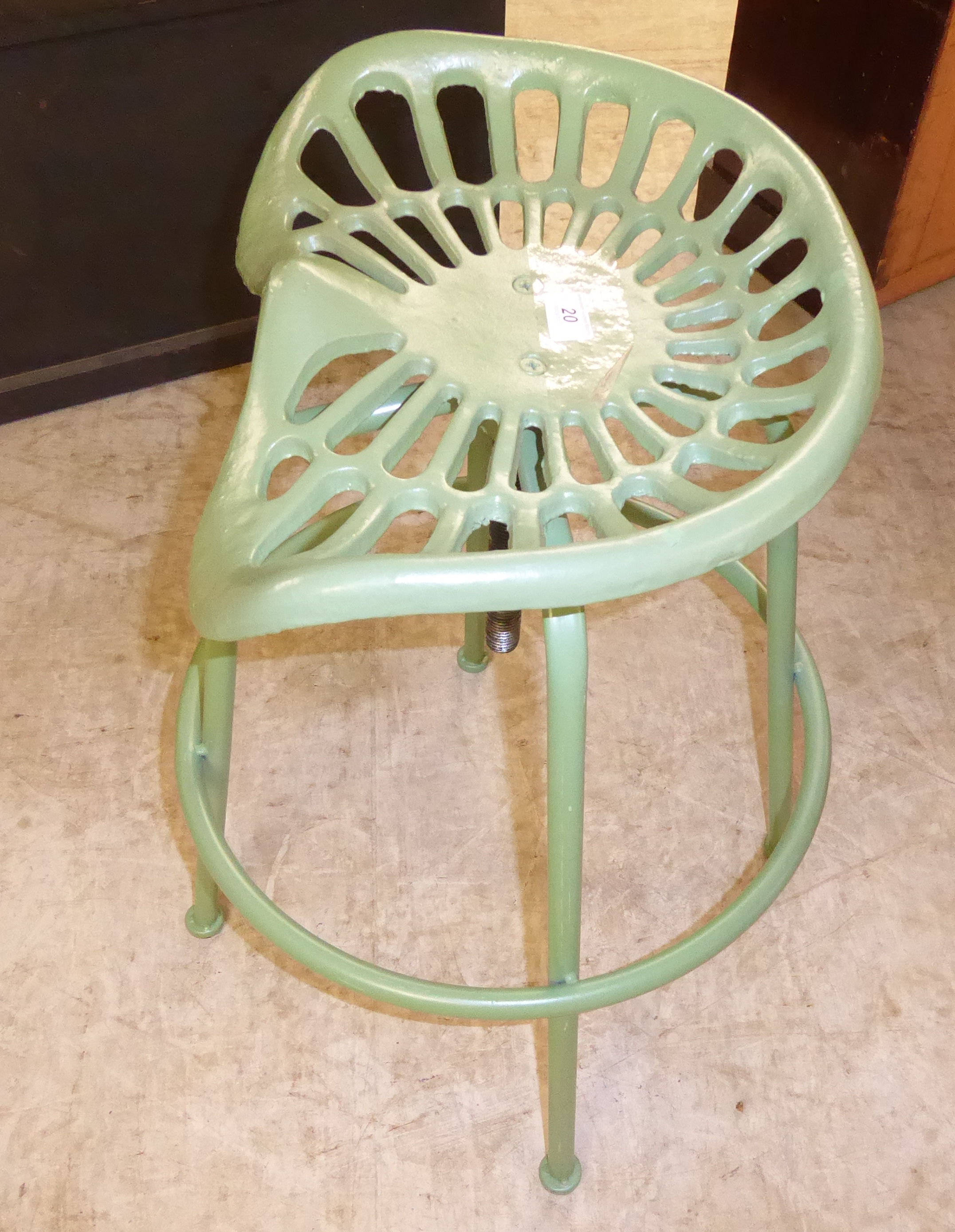 An (as new) green painted cast iron and steel stool with a height adjustable tractor style seat,