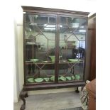 A George III and later mahogany bookcase with a moulded cornice, over a pair of glazed doors,