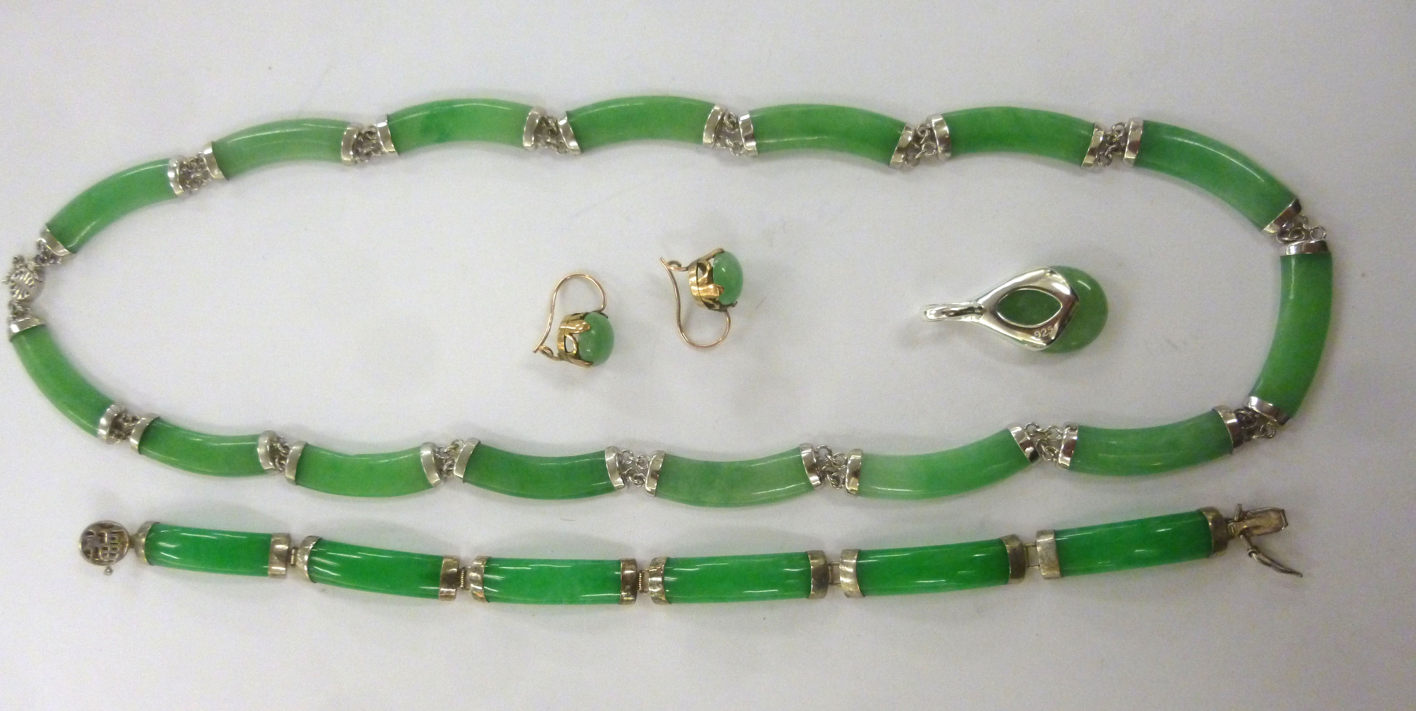 A suite of jade jewellery with silver mounts comprising a necklace, bracelet,