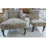 Two similar late Victorian tapestry upholstered nursing chairs, each raised on turned,