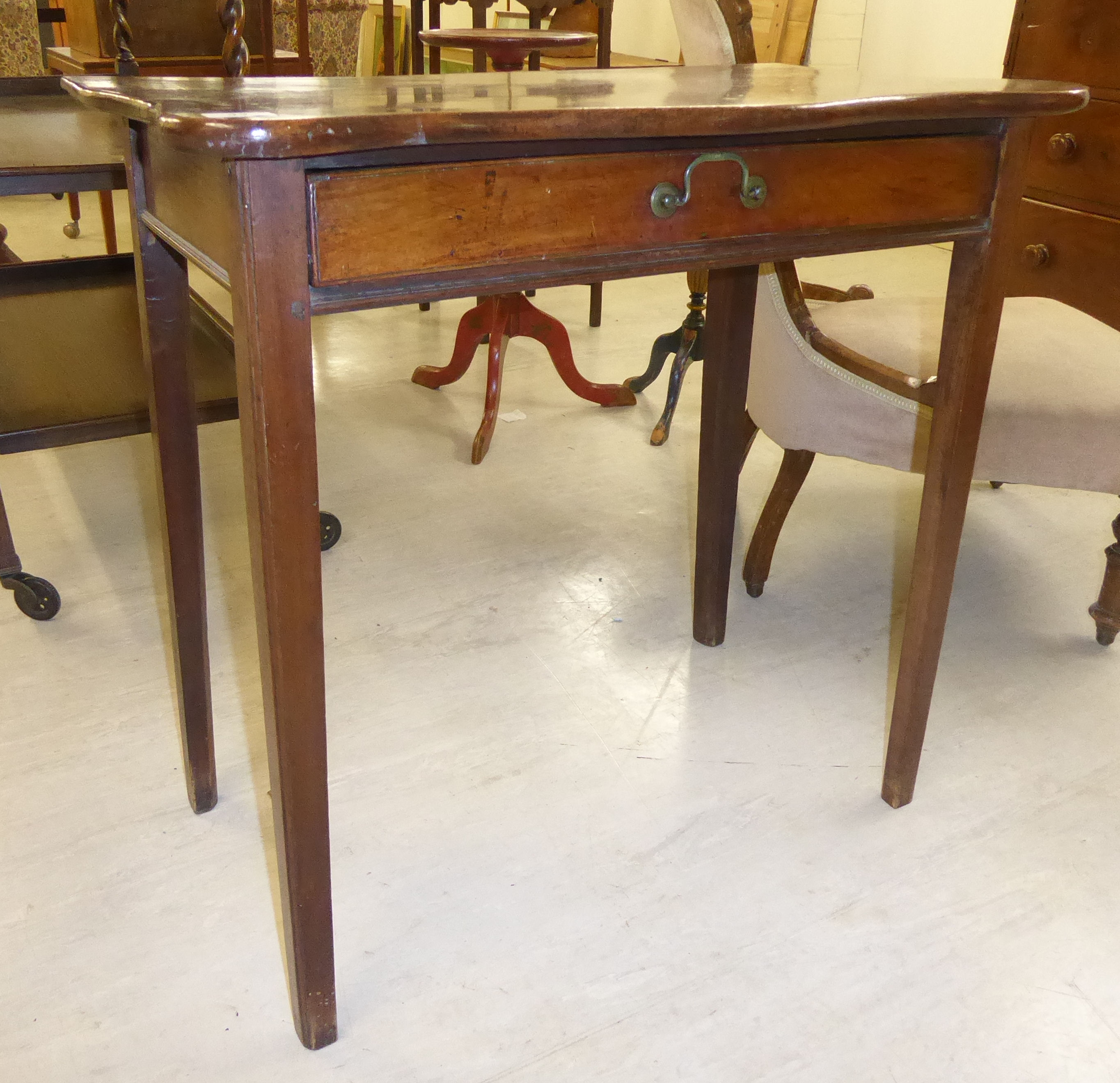 A late Victorian mahogany serpentine front hall table with a single drawer, raised on square,