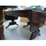 A mid/late 19thC sofa style mahogany dining table, the drop ends on draw supports,