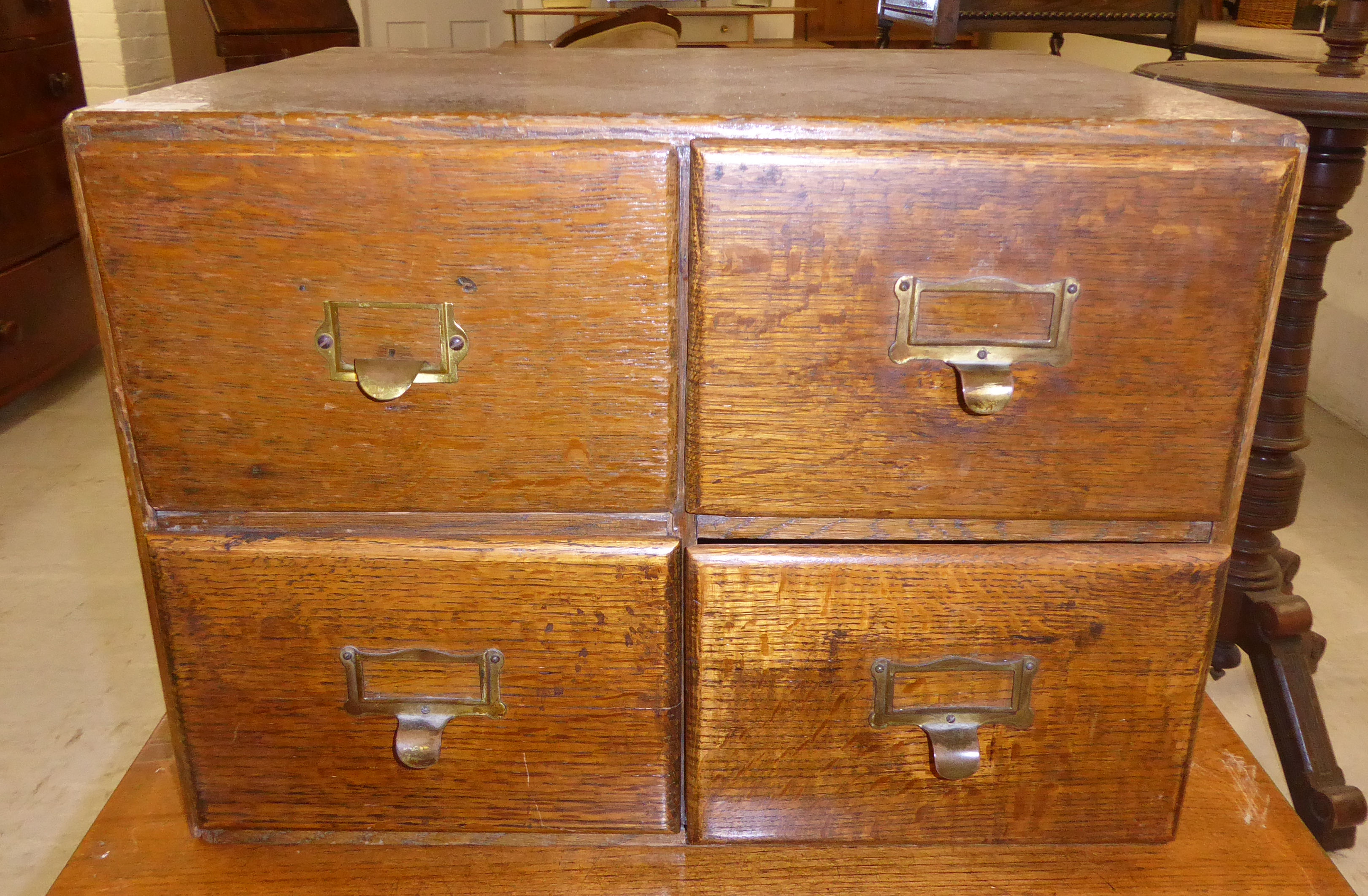 A 1920s stained oak table top, four drawer filing cabinet,