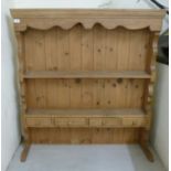 A modern waxed pine plate rack with two open shelves,
