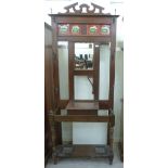An Edwardian mahogany hallstand with a tiled frieze, over a mirror and a glove drawer,