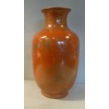 A 20thC Chinese iron red glazed vase with a narrow, flared neck,