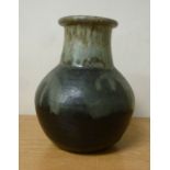 A black and green drip glazed studio pottery bottle vase of bulbous form with a wide,