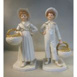 A pair of Edwardian Royal Worcester ivory glazed and gilded china standing figures, a boy and girl,