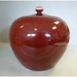 A late 19thC Chinese sang de boeuf porcelain bulbous jar and cover with a knop finial 9''h