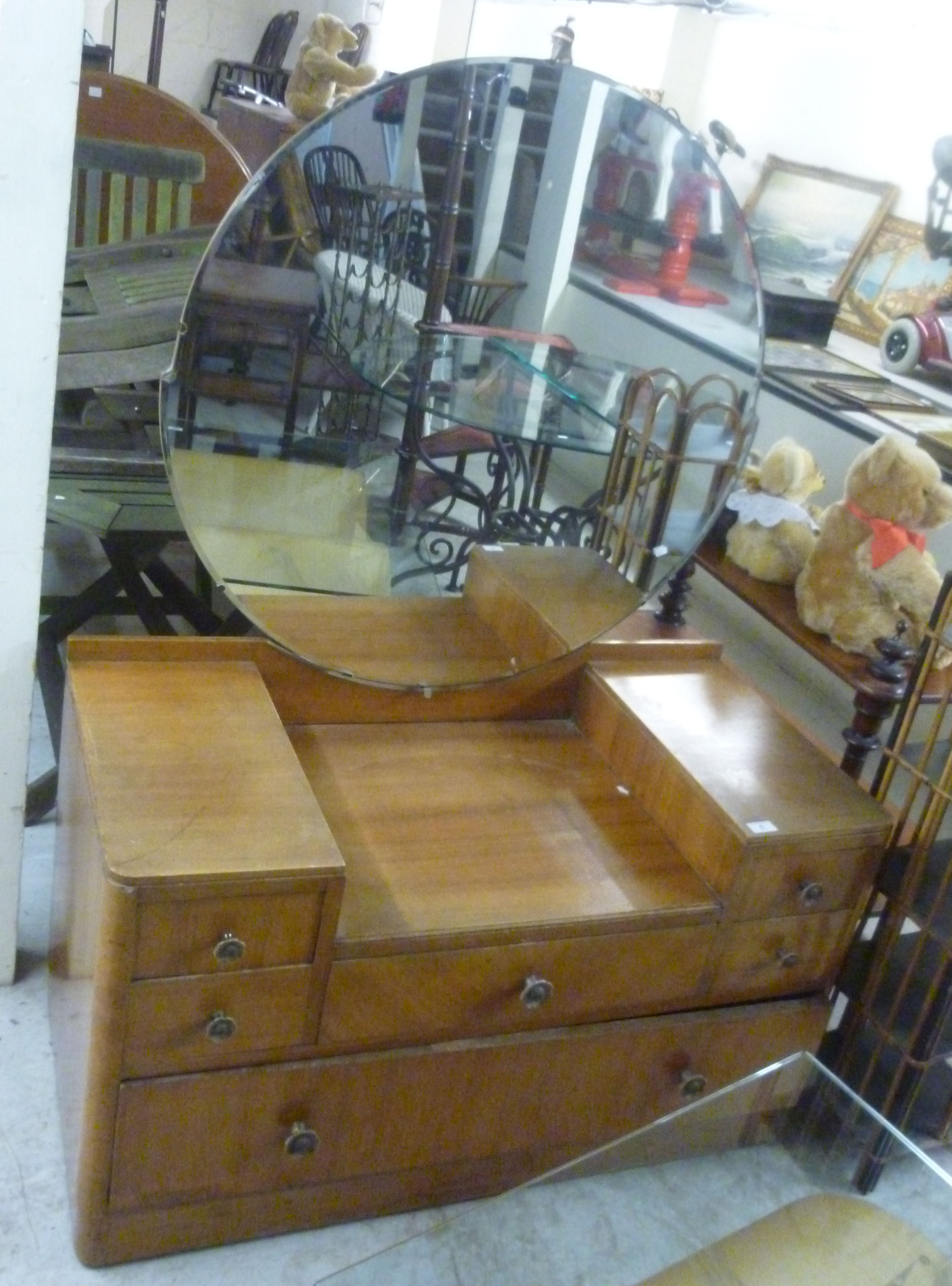 An Art Deco satin mahogany dressing table, surmounted by a substantial circular bevelled mirror,