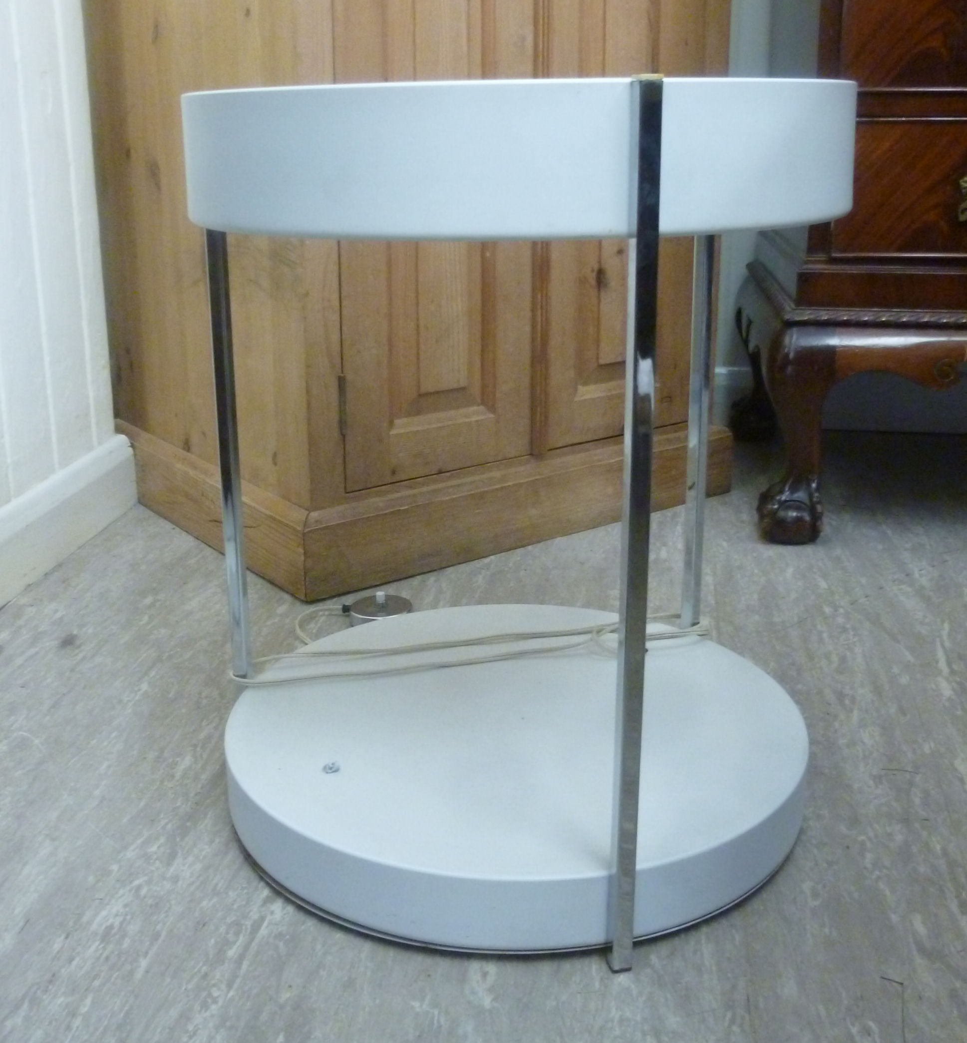 A 1960s white enamelled two tier floorstanding shelf unit with section tubular chromium plated