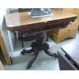 A mid Victorian mahogany tea table with a rotating foldover top and a carved frieze,