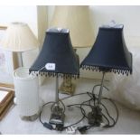 A pair of modern silvered metal table lamps with ram's head ornament and attendant,