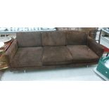 A 1960s three person settee with a low, level back and straight arms,