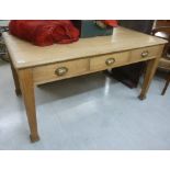 A 1920s bleached oak work table, the three in-line frieze drawers with brass grab handles,