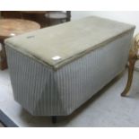A Lloyd Loom style blanket box, the fabric covered hinged lid raised on tapered,