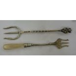 Two silver trident forks, one with a square,