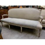 An 'antique' finished cream painted and carved Louis XVI style showwood framed settee with a round