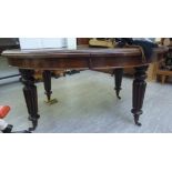 A late Victorian mahogany wind-out dining table, raised on turned, tapered,