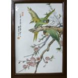 A modern Oriental painted porcelain plaque, featuring parrots perched amongst flowering branches,