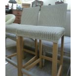 A pair of modern painted cream coloured Lloyd Loom breakfast bar chairs,