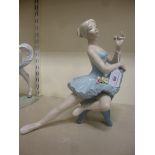 A Spanish porcelain figure, a seated ballerina,
