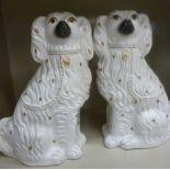 A pair of late Victorian Staffordshire ivory glazed pottery seated King Charles Spaniels with