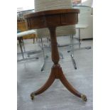 A modern reproduction of a late 18thC walnut finished drum top table with three frieze drawers,