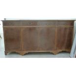 A mid 20thC Masters of Eton yew wood finished breakfront sideboard with four in-line short drawers,