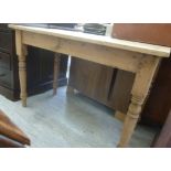 An early 20thC waxed pine work table, the planked top raised on ring turned,