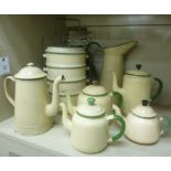 Cream coloured and green enamelled steel cooking wares: to include stacking pans and teapots;