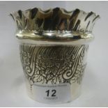 A late Victorian silver cache pot with embossed floral and scrolled decoration and a crimped rim