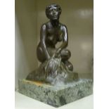 A cast and patinated bronze figure, a nude, seated on a rock, on a mottled green onyx plinth 8.