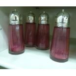 Four identical, faceted, tapered cylindrical Cranberry glass casters with domed,