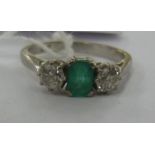 An 18ct white gold ring set with a central emerald,