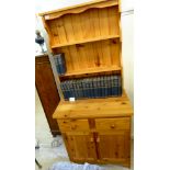 A modern honey coloured pine cottage dresser with a planked, shelved superstructure,