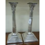 A pair of loaded silver candlesticks, each with an in-curved,