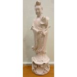An early/mid 20thC Chinese blanc de china robed, standing female figure, holding a lotus flower,