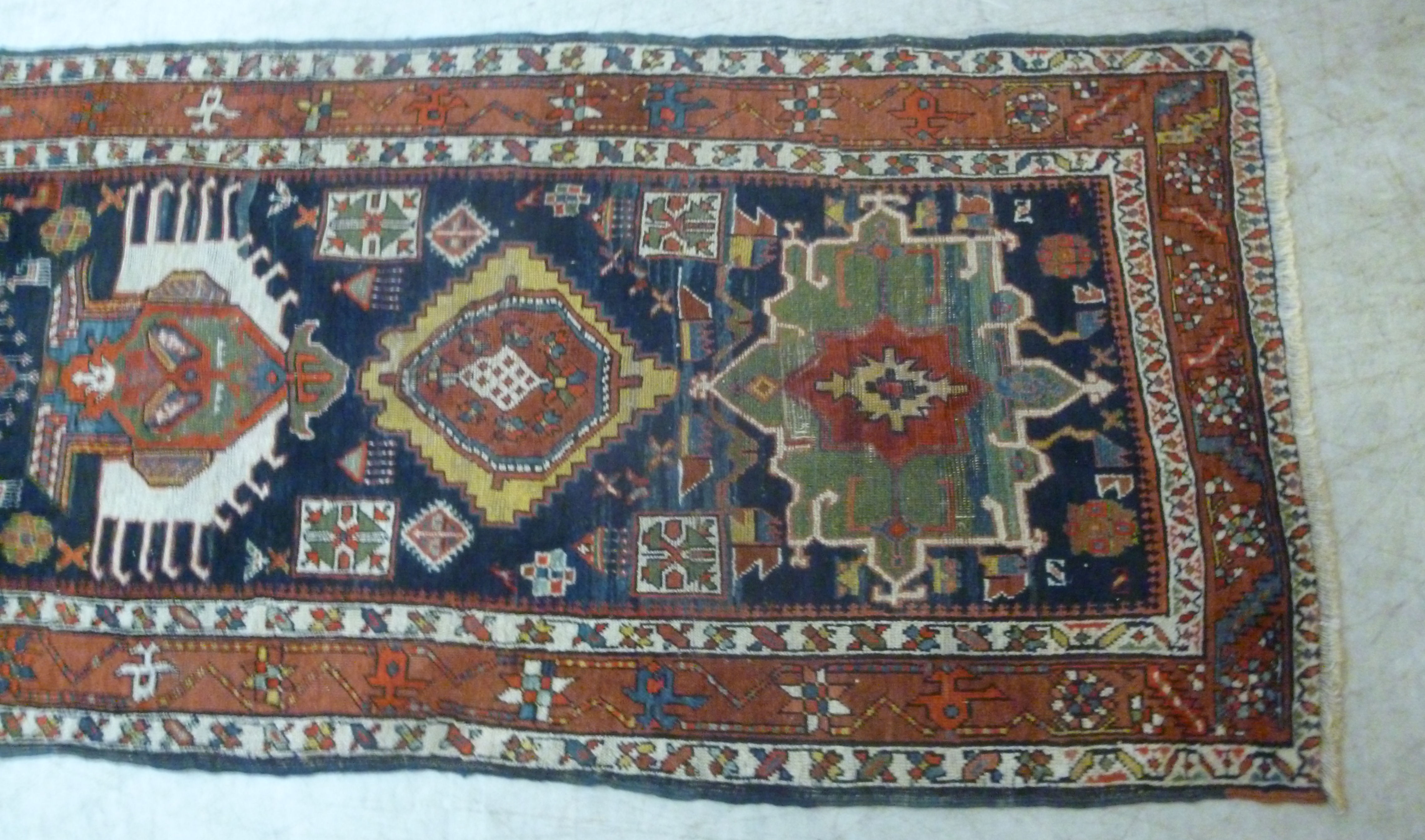 A Caucasian runner with repeated stylised diamond motifs on a blue and red ground 154'' x 39'' - Image 2 of 5
