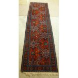 A Caucasian runner with stylised designs on a blue and red ground 110'' x 32''