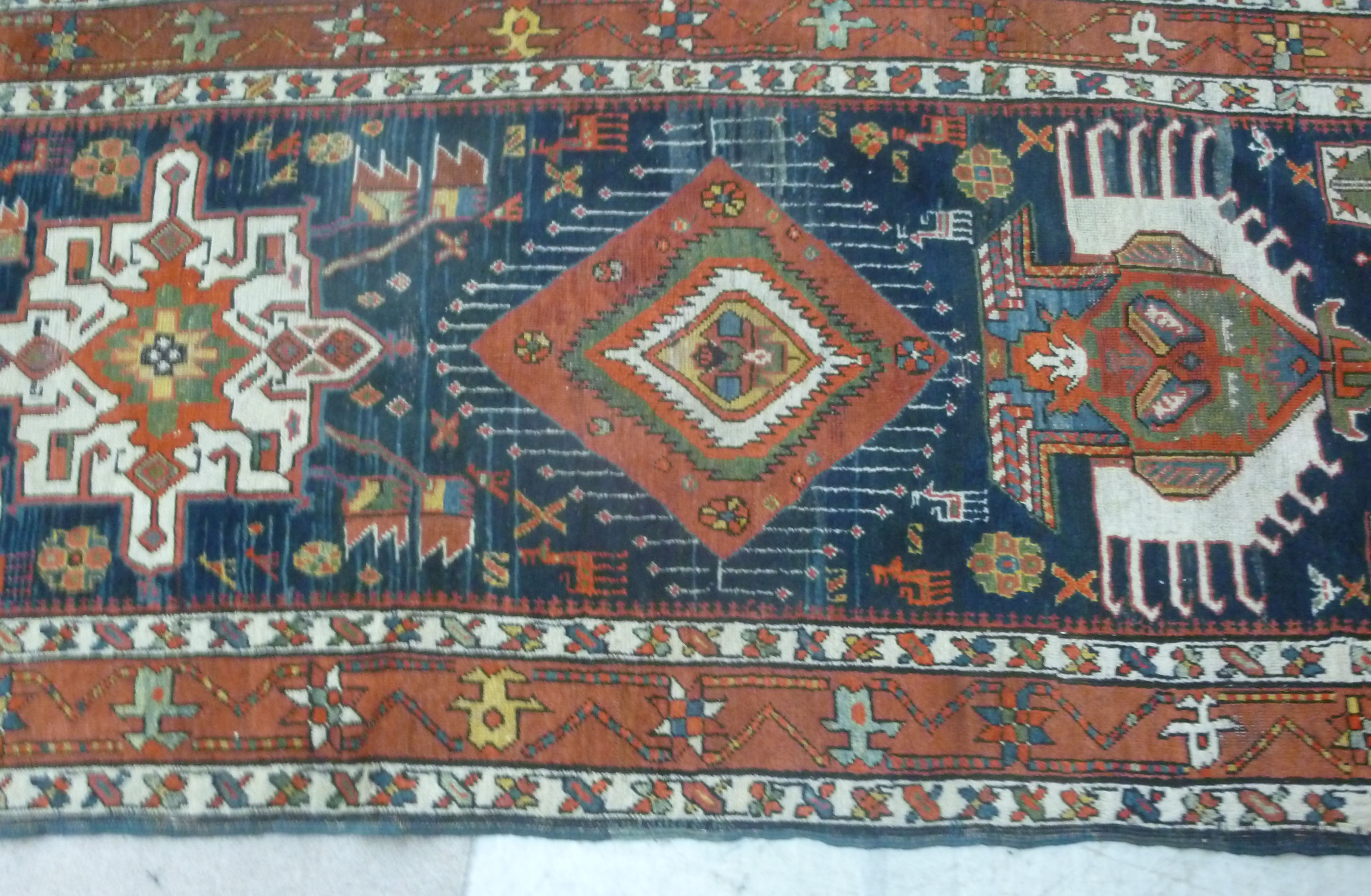 A Caucasian runner with repeated stylised diamond motifs on a blue and red ground 154'' x 39'' - Image 3 of 5