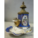 A late 19thC Continental porcelain inkwell, decorated with floral vignettes and gilded blue designs,